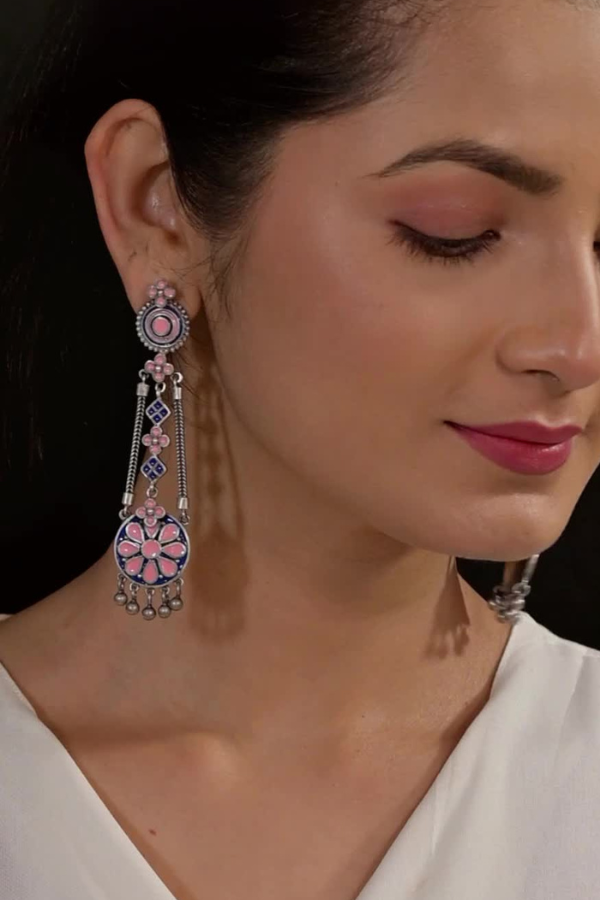 ornate earrings with pink and blue accents.