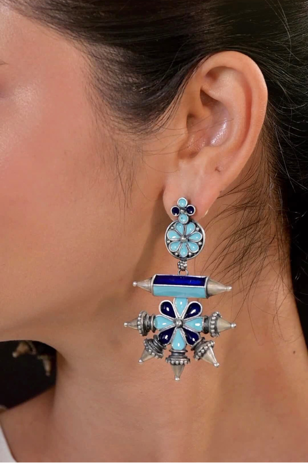 decorative earring with blue and silver design.