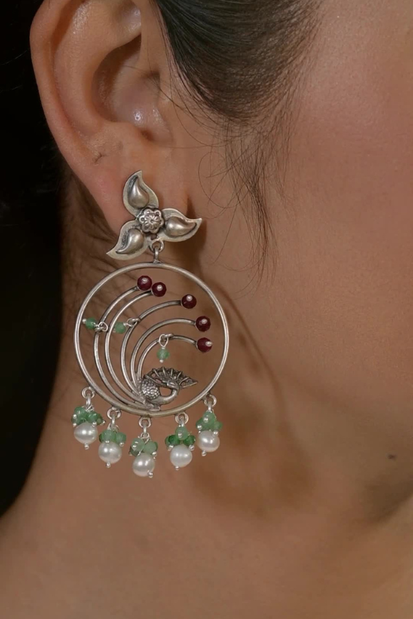 silver earring with pearls and green stones.