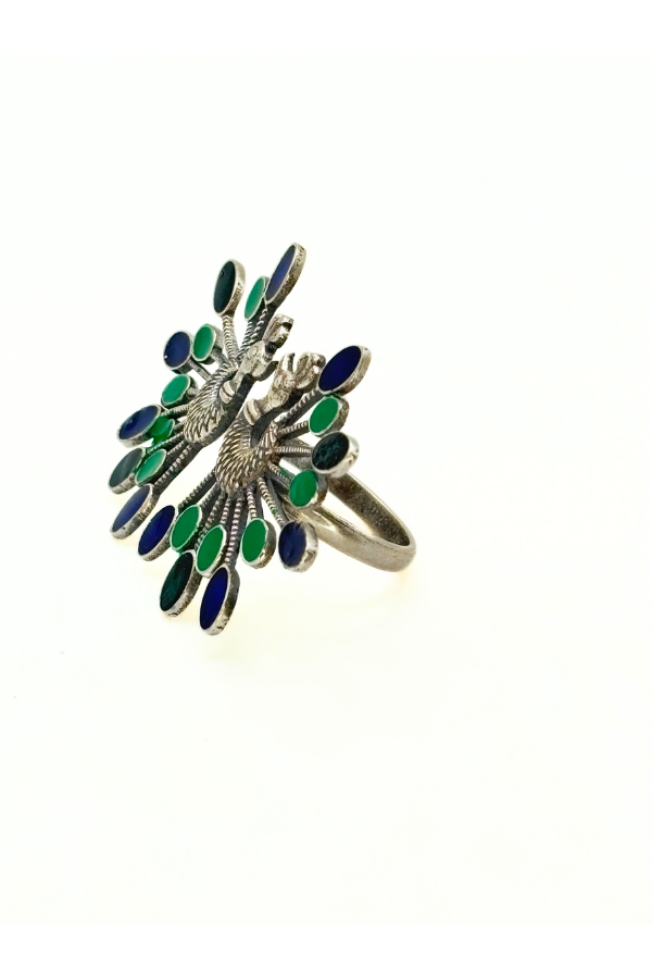 Silver ring with green gemstones on a white background