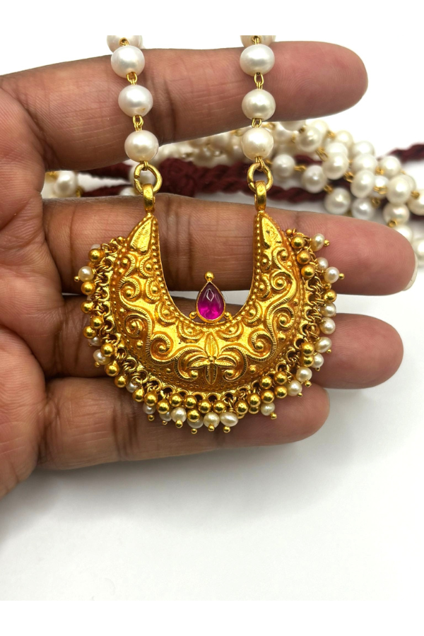Gold plated pendant chain with pink gemstone.