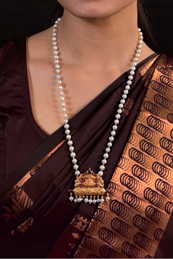 Pearl necklace with a gold pendant.