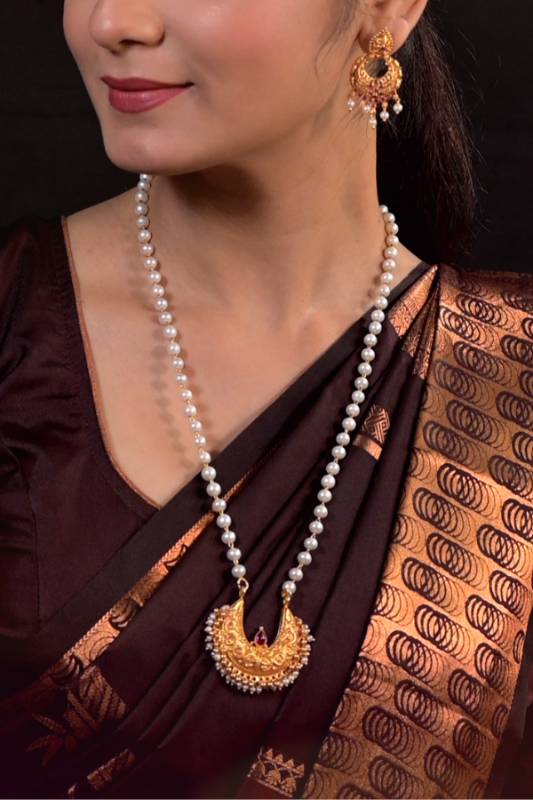 Pearl necklace and gold earrings.